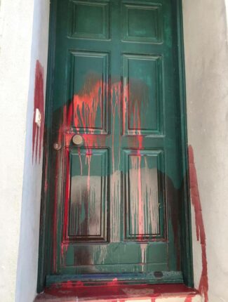 The vandalised doorway of a refugee support worker in Greece