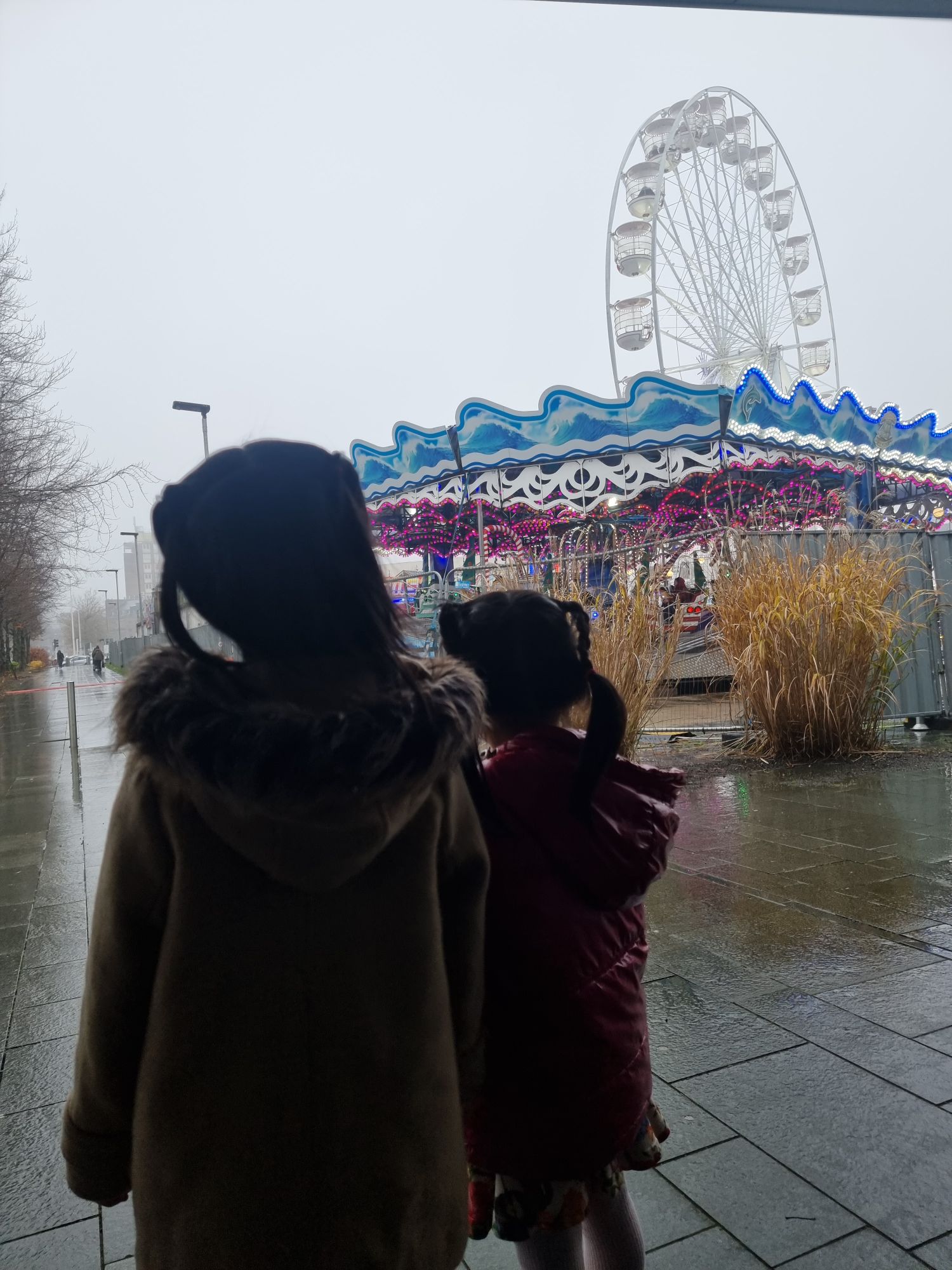 Two little girls look at the rides with excitement